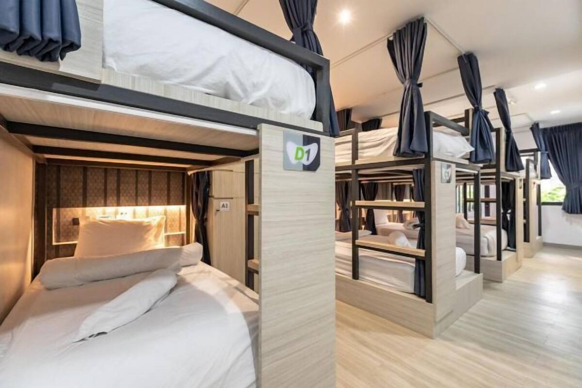 Een slaapkamer met een stapelbed, een houten hoofdbord, een klein bureau en een kledingkast.