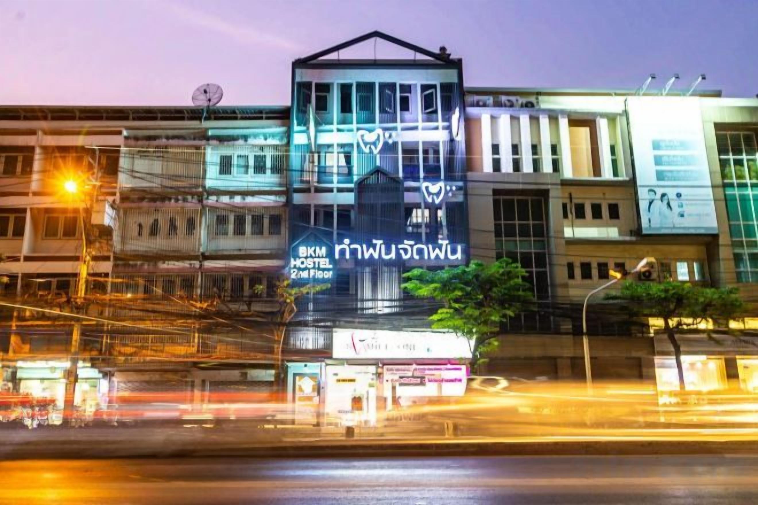 A multi-story building with signage for a hostel on the 2nd floor.