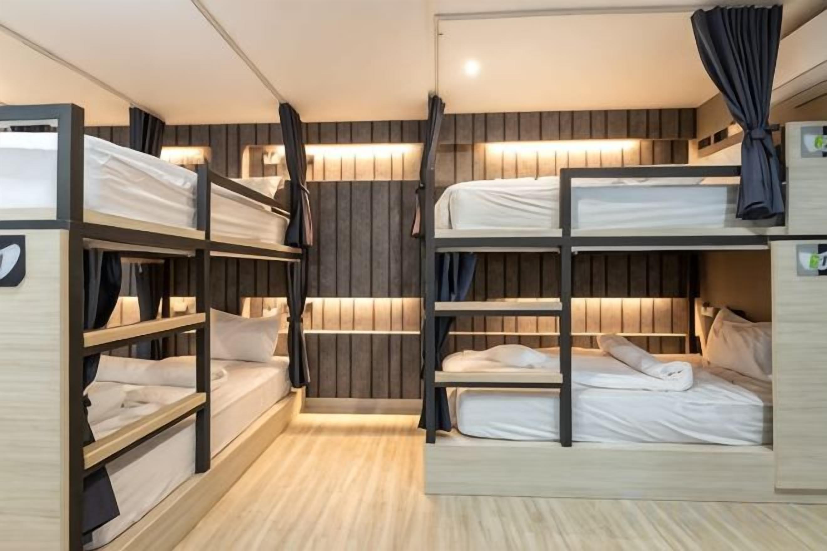 A bunk bed room with wooden walls and a ceiling light.