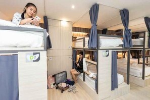 Quarto tipo dormitório com beliches, escrivaninha e cadeira.