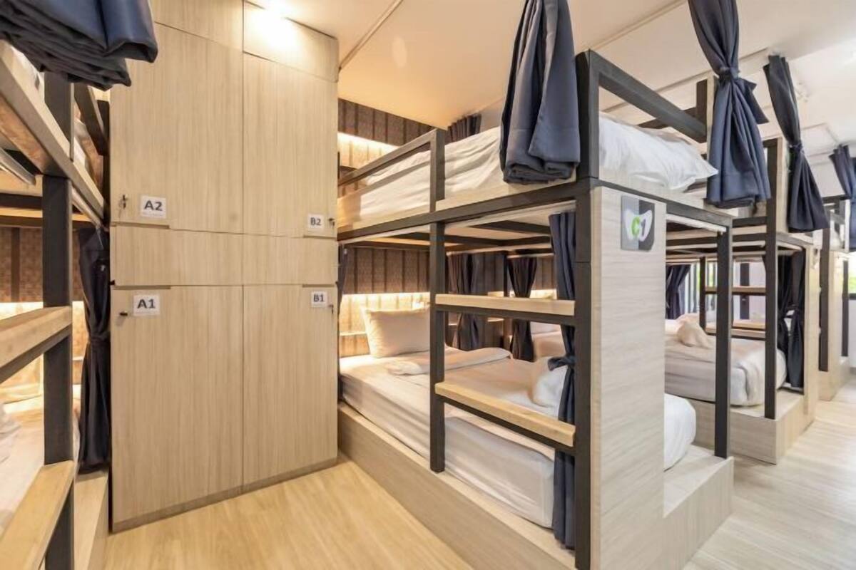 Een slaapkamer met een stapelbed, houten wanden en een kledingkast.