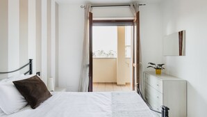 A bedroom with a bed, a dresser, a mirror, and a potted plant. - HQ Aparthotel Milano Inn - Smart Suites -  Standard one bedroom Apartment (Cinisello Balsamo)
