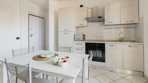 A modern kitchen with white cabinets, a microwave, and a dishwasher. - HQ Aparthotel Milano Inn - Smart Suites -  Standard one bedroom Apartment (Cinisello Balsamo)