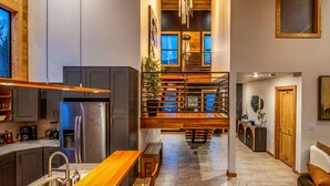 A modern kitchen with a stainless steel refrigerator, wooden counter, and a built-in bench. - Lakefront - Alpine Views - Daily Moose (Black Hawk)