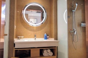 A bathroom with a round mirror, a sink, and a shower. - Metropolo Jinjiang Hotels (Fuxin Yingbin Street Railway Station) (Fuxin)