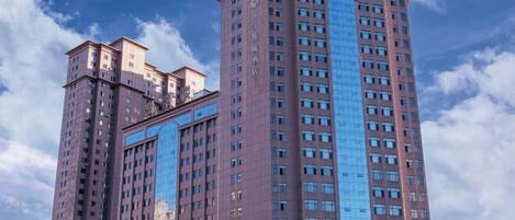 A high-rise building with multiple floors, large windows, and a prominent central glass facade.