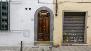 A building with a wooden door, a metal shutter, and a number '17' on the wall.