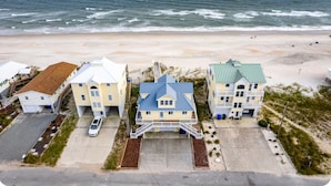 A beachfront property with three houses, a parking area, and a view of the ocean. - Beach Front with Charm and Luxury. 2 person Hot Tub on Deck. Beautiful Loft! (North Topsail Beach)