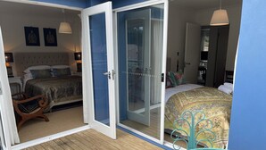 A bedroom with a large bed, a wooden floor, and a sliding glass door leading to a balcony. - TREETOPS PENTHOUSE ROSE BAY, SYDNEY 3 BEDROOMS LOUNGE KITCHEN/GARAGE PARKING (Rose Bay North)