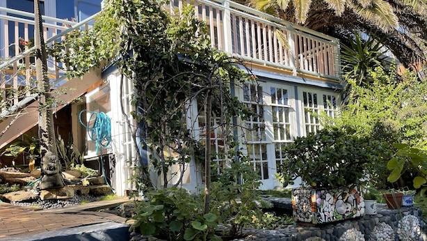A building with a balcony, steps leading to the entrance, and a garden area with a stone wall and decorative shells. - TREETOPS PENTHOUSE ROSE BAY, SYDNEY 3 BEDROOMS LOUNGE KITCHEN/GARAGE PARKING (Rose Bay North)