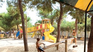 A sandy playground with a seesaw, a yellow slide, and a wooden play structure. - Lovely apartment in villa for 5 people with pool, A/C, terrace and pets allowed (Gallipoli)