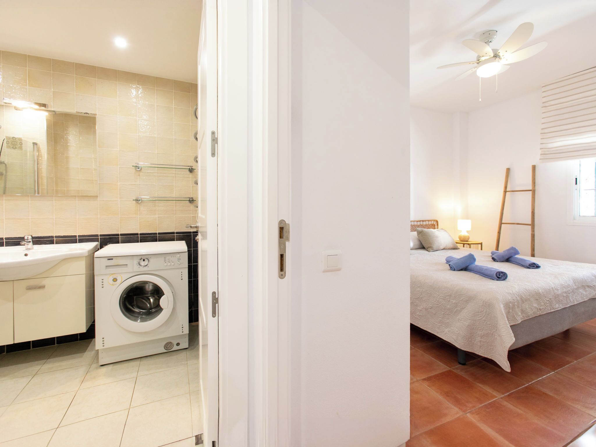 A modern bathroom with a washing machine, a sink, and a mirror.