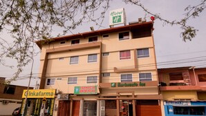 A multi-story building with a pharmacy, a bar, and a hotel sign. - Hotel Barlovento Inn Piura (Piura)
