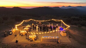 An outdoor event with tables and chairs arranged on a flat surface, surrounded by a string of lights. - Starview Ranch: 3 homes w/ 7 bdrms, pool, sauna, spa & gym on 50 beautiful acres (Miramonte)