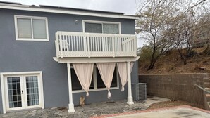 A residential building with a balcony, a stone patio, and a concrete driveway. - Nice remodeled House for rent in West side of Palmdale (Palmdale)