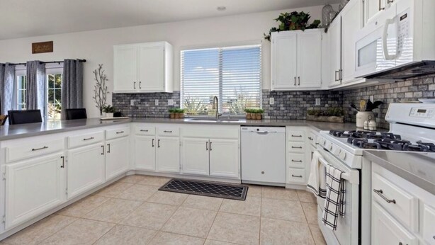 A modern kitchen with white cabinets, a built-in stove, and a large window providing natural light. - Nice remodeled House for rent in West side of Palmdale (Palmdale)