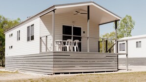 A single-story mobile home with a covered porch and a small patio area.