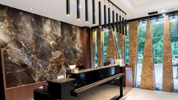 A modern reception desk with a marble wall and a glass partition.