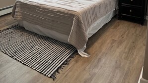 Une chambre à coucher avec un lit, une table de chevet, un élément décoratif mural et une fenêtre.