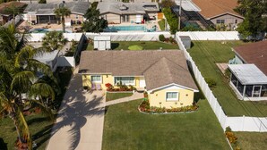 A single-story house with a front yard, a swimming pool, and a covered patio area. - PALM BEACH GARDENS  GUEST HOUSE (Palm Beach Gardens)