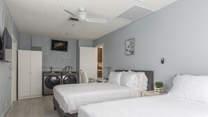 A bedroom with two beds, a washing machine, and a ceiling fan. - PALM BEACH GARDENS  GUEST HOUSE (Palm Beach Gardens)