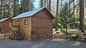 Eine rustikale Holzhütte mit Veranda und Kiesgrundstück.