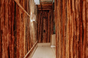 A narrow hallway with wooden walls and a white floor. - Majaro Apartments (Tulum)