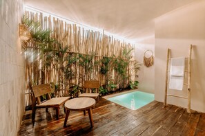 A wooden deck with a pool, bamboo wall, and seating area. - Majaro Apartments (Tulum)