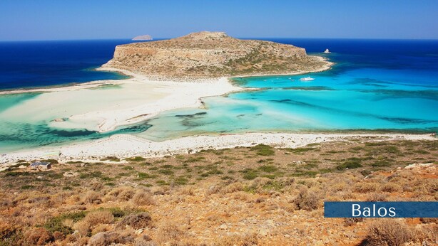 A coastal landscape with a prominent rocky island and a sandy beach.