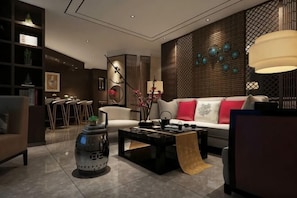 A modern living room with a sofa, coffee table, and decorative items. - Jucheng Siji Holiday Hotel (Ju County)