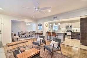 A spacious living room with a dining area, a kitchen, and a ceiling fan. - Mid-Century Modern Escape in Central Lakeland! (Lakeland)