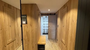 Un pasillo con paredes de madera y un banco.
