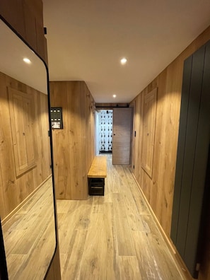 Un corridoio con pareti in legno e una panca.