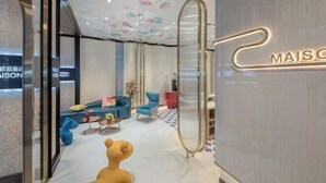 A modern hotel lobby with a sofa, chairs, and a bear sculpture. - MAISON Hotel (Liuyang Economic Development Zone, Coach Station, Liuyang) (Liuyang)
