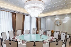 A formal dining room with a round table, chairs, and a chandelier. - Zijin International Hotel (Yan'an)