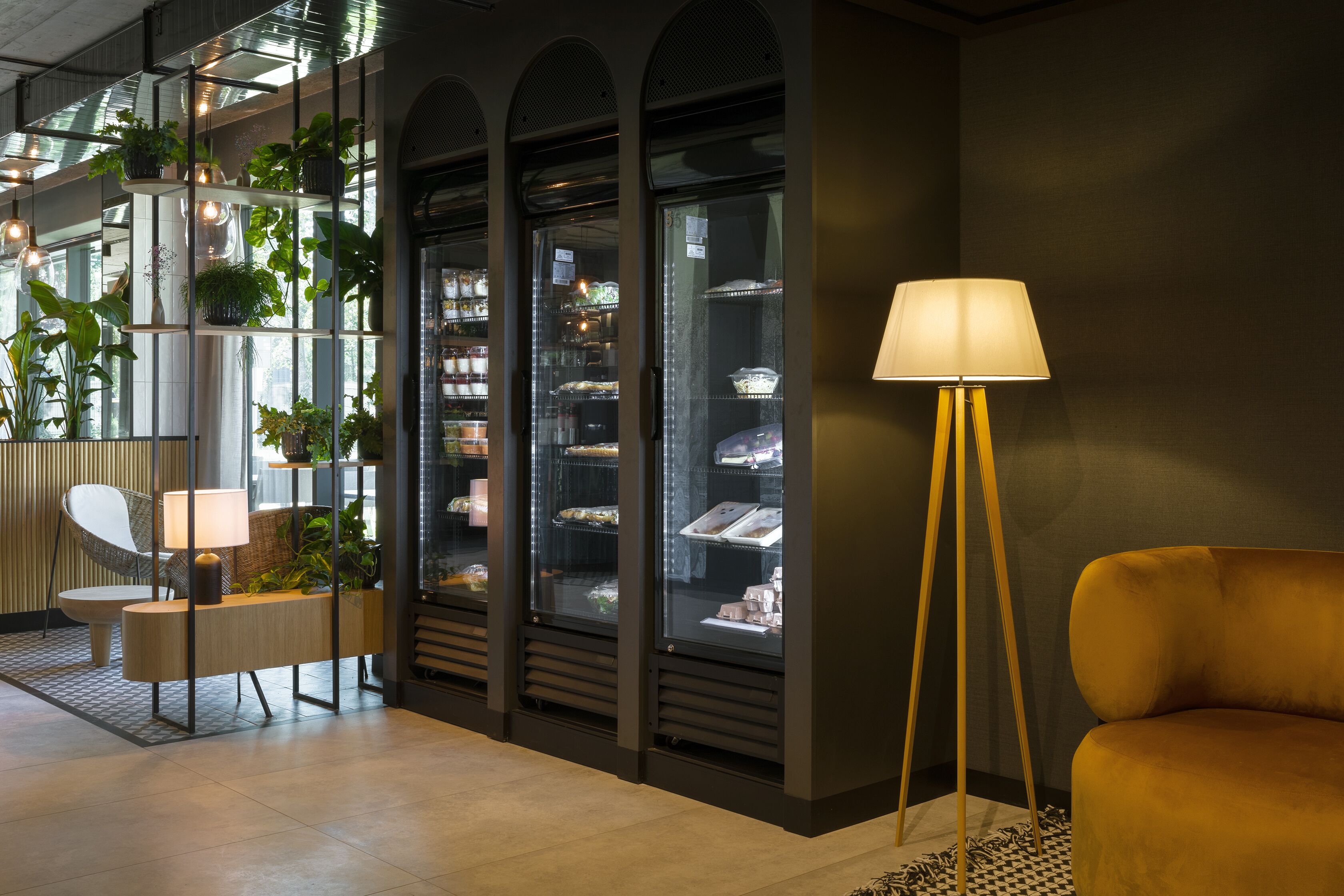 Un interior moderno con una zona de estar, una exhibición de plantas y una presentación de alimentos.