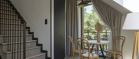 Un interior moderno con una escalera, comedor y ventanas amplias.