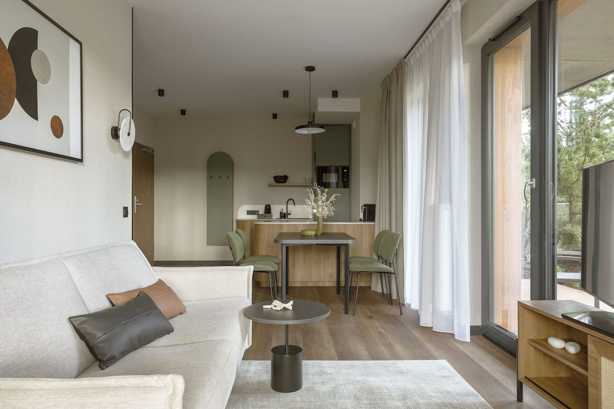 Ein modernes Wohnzimmer mit einer Couch, einem Couchtisch und einem Essbereich mit Stühlen und einem Tisch.