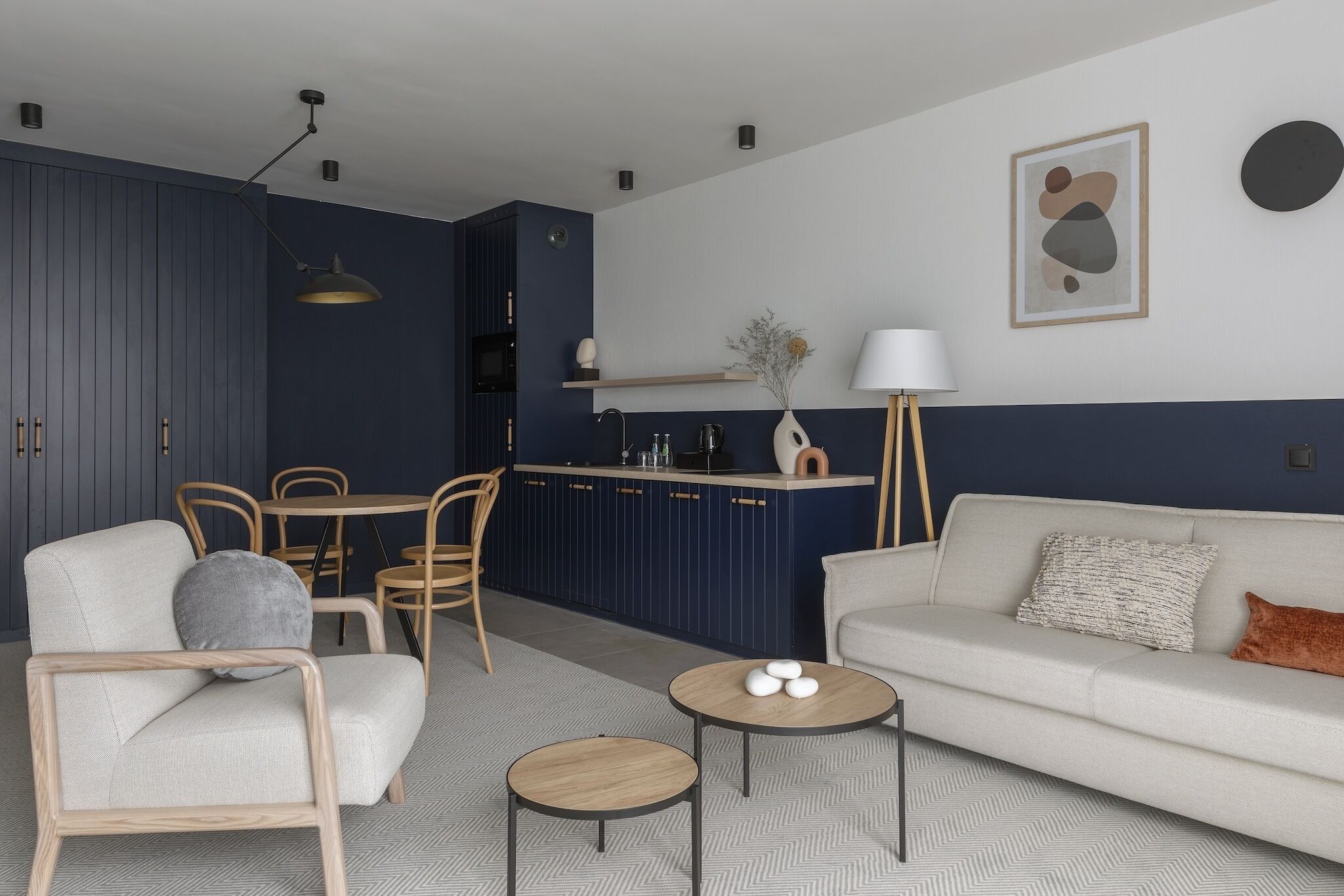 A modern living room with a sofa, chairs, a coffee table, and a dining area with a table and chairs.