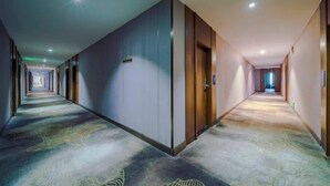 A long, narrow hotel corridor with a patterned carpet, wooden doors, and recessed lighting. - HengYangYi’nian Yuexiang Hotel (Hengyang)
