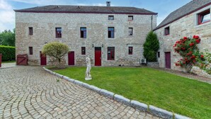 A stone building with a courtyard, a statue, and a cobblestone path. - Holiday home in Melreux-Hotton with sauna (Melreux-Hotton)