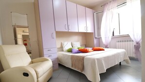 A bedroom with a bed, a chair, and a wardrobe. - Holiday Apartment “Claudia” with Air Conditioning and Balcony (otranto)