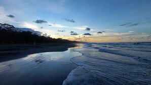 A beach with a calm sea, a clear sky, and a distant mountain. - Apartment by the Caribbean sea. 4 min walk from the beach! Air-conditioning! (Limón Province)