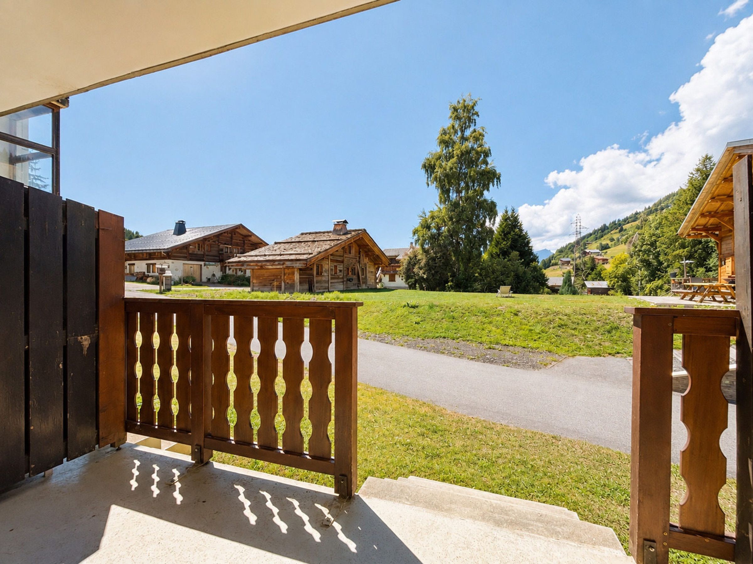 A wooden fence with a view of traditional houses and a clear sky.