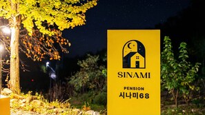 A yellow sign with a house and moon icon, labeled 'SINAMI Pension' and '인하미 68'.