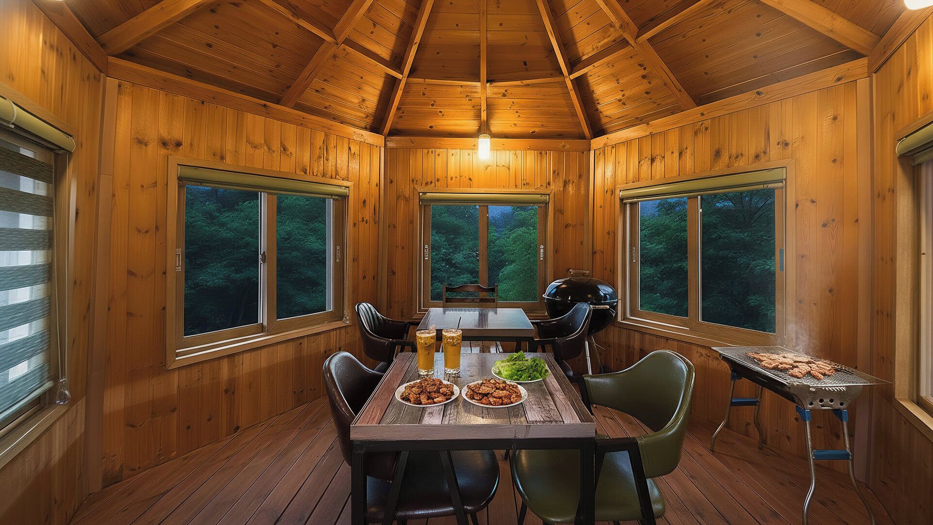 Comedor de una cabaña de madera con una mesa dispuesta para dos, una parrilla y ventanas amplias.
