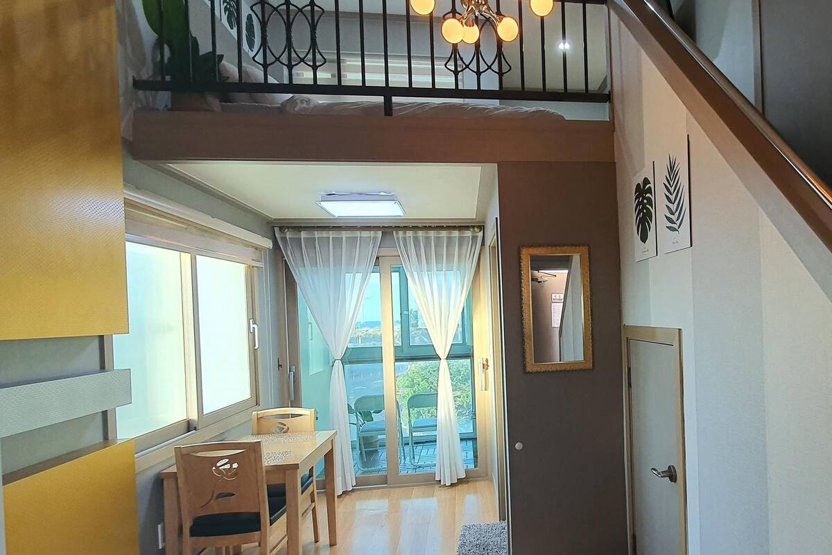 Un espace repas comprenant une table et des chaises, un escalier et une vue sur l’extérieur.