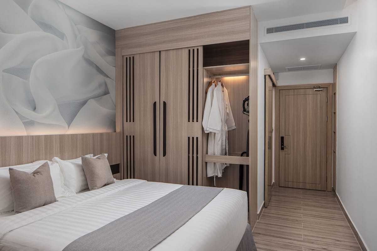 Una camera da letto moderna con un letto grande, un armadio con specchio e un'opera d'arte appesa al muro.