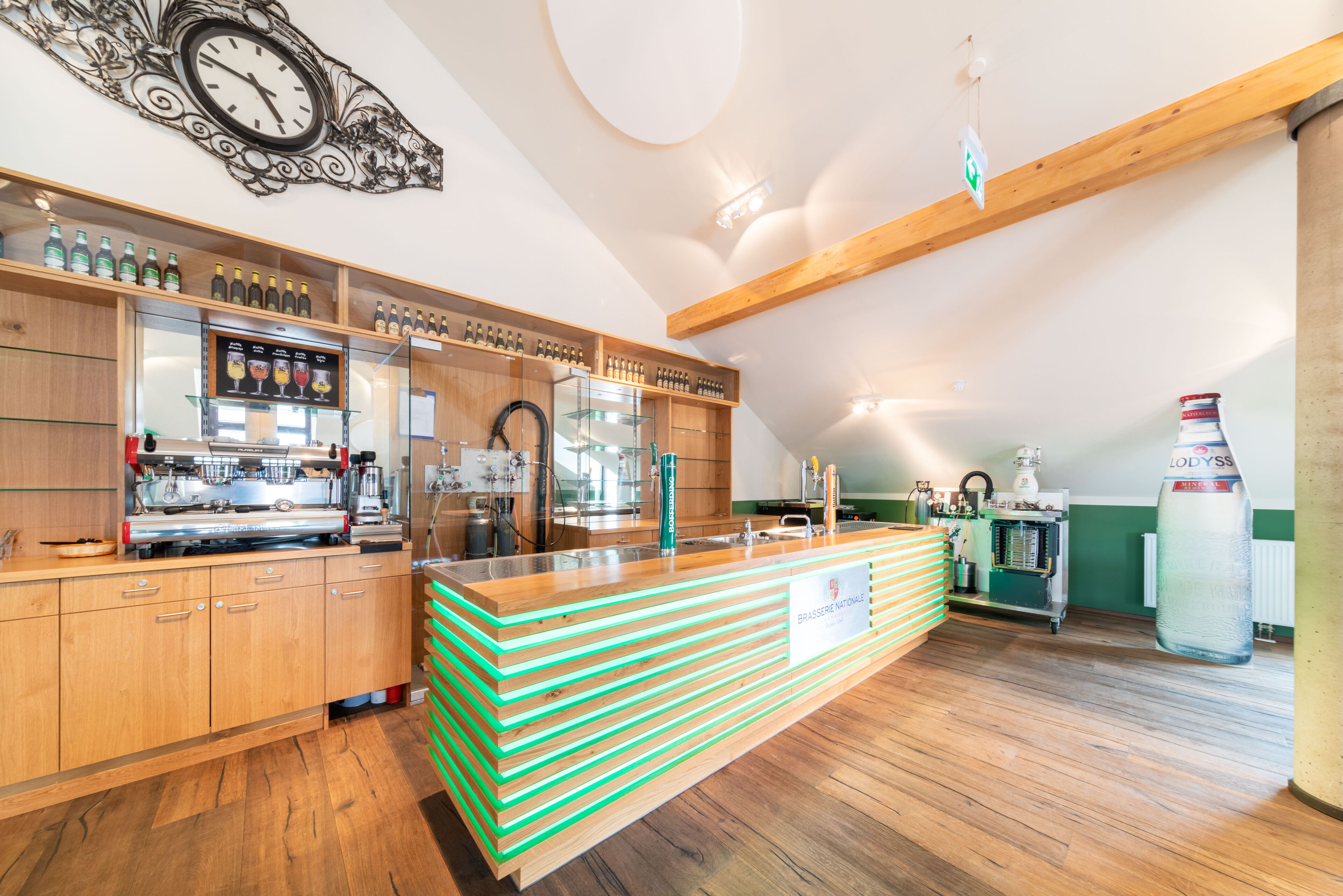 A modern kitchen with wooden cabinets, a central island, and a clock on the wall.