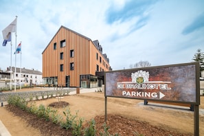 A modern building with a sign for De Brau Hotel Parking. - De Brauhotel (Käerjeng)